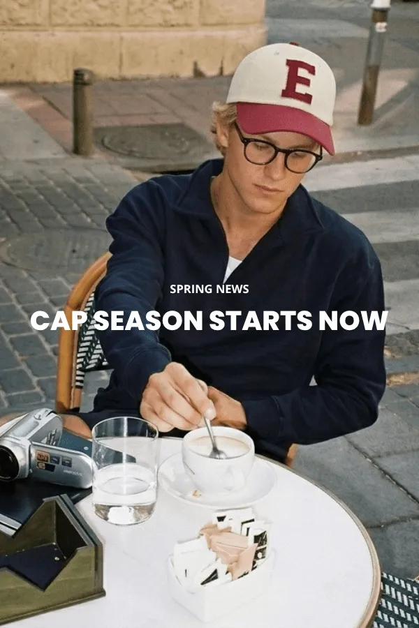 Mies istuu puisella laatikolla studiossa ja käyttää klassista ruskeaa huopacowboyhattua leveällä lierillä, tummaa farkkupaitaa ja farkkuja.